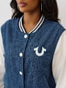 CHAQUETA UNIVERSITARIA DE MEZCLILLA CON ALAS DE CRISTAL